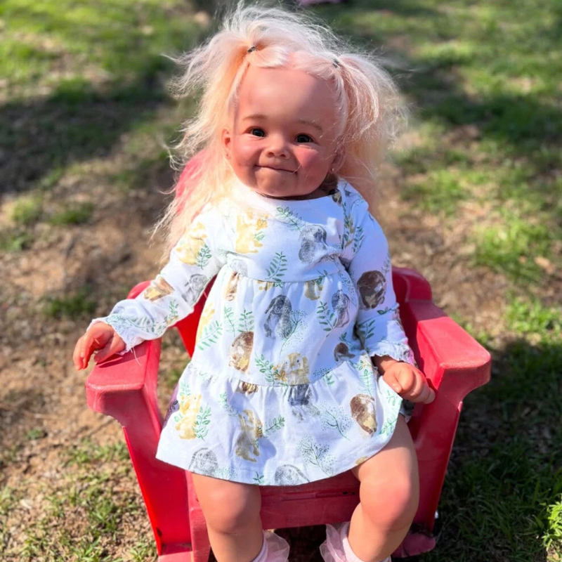 Little girl doll sitting on a chair with beautiful hair styled in two ponytails, wearing a cute outfit and smiling softly.